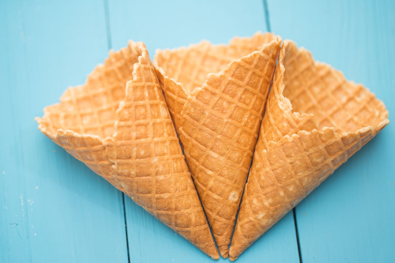 Two waffle cones with a tourquoise background